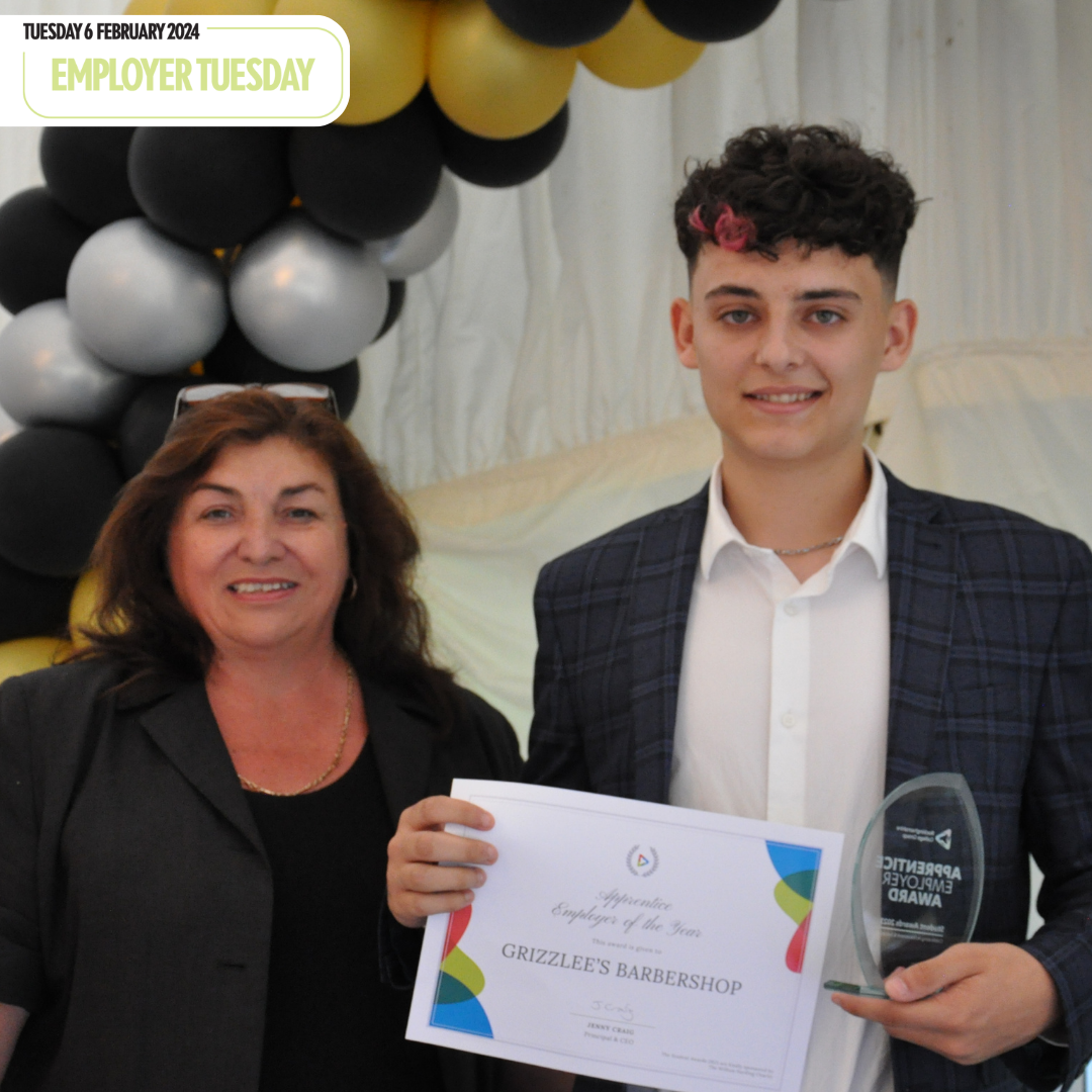 Oliver holds certificate that says 'Apprentice Employer of the Year' at student awards ceremony.