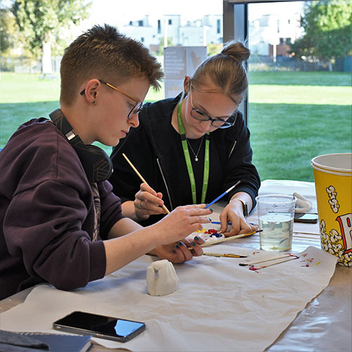 Two Students Painting Hand Cast