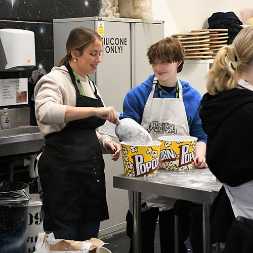 Two Students Scooping Plaster Powder